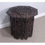 A highly and heavily carved Anglo-Indian octagonal occasional Table, carved top above folding