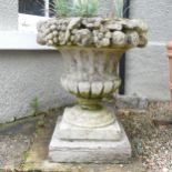 A Pair of weathered stoneware garden Urns, with moulded floral borders, raised on plinth base, W