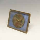 A small gilt metal Travelling Clock, on easel stand, the circular dial depicting a classical