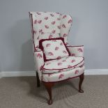 A 20thC wingback Armchair, upholstered in white fabric with horses, on carved cabriole legs, W 75 cm