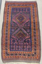 Tribal Rugs; an old Afghan Rug, plum coloured ground with geometric patterned dark orange border,