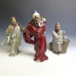 A large 20th Chinese pottery figure of an Elder, modelled with long beard, restuck, in red gown, H