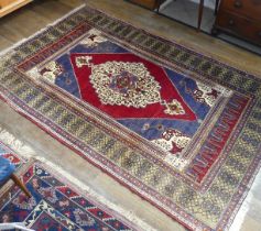 Tribal Rugs; an old Turkish Yahyali Rug, blue and red ground with cream central medallion, within