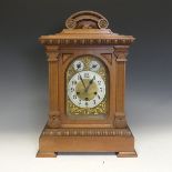An early 20th century German chiming Mantel Clock, in an architectural carved walnut case, the brass
