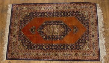 Tribal Rugs; an old Persian finely knotted 100% silk rug, burnt orange ground with dark blue