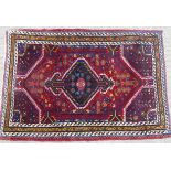 Tribal Rugs; a Persian Qashqai Rug, red ground, thick wool pile on cotton base, worn along one edge,