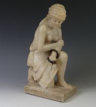 An alabaster sculpture of Cleopatra, modelled half nude, kneeling and with a brown snake coiled