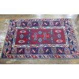 Tribal Rugs; a Turkish Rug, blue and red ground with all over geometric pattern set within a wide