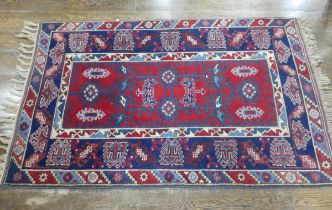 Tribal Rugs; a Turkish Rug, blue and red ground with all over geometric pattern set within a wide