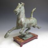 A 20thC Tang-style bronze Horse, modelled in galloping pose, H 30cm (including plinth) x L 36cm,
