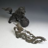 A 20thC Chinese bronze figure of a Foo Dog, modelled perched on ball, H 25cm, together with a