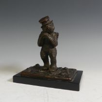 A novelty Vesta holder in the form of a gilt bronze Bear, with a top hat and a basket on his back,