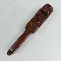 An Early Folk treen Nut Cracker, possibly 17th century, featuring a totem style head in naïve