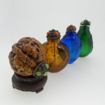 A Chinese 'Luohan' carved walnut shell Snuff Bottle, depicting faces, with metal and stone