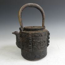 A Japanese cast iron Tetsubin, of cylindrical form with relief work patterns, with swing handle with