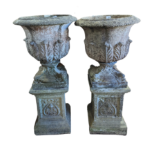 A Pair of weathered reconstituted stone garden Urns of campana form, raised on Art Nouveau