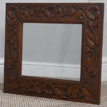 An Arts and Crafts Wall Mirror in the manner of Arthur Simpson, carved oak frame with stylised