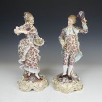 A pair of early 20thC Continental porcelain Figures, in floral dress, raised on gilt scroll bases,