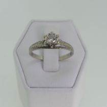 A single stone diamond Ring, the circular stone approx. 0.15ct, illusion set in a textured high claw