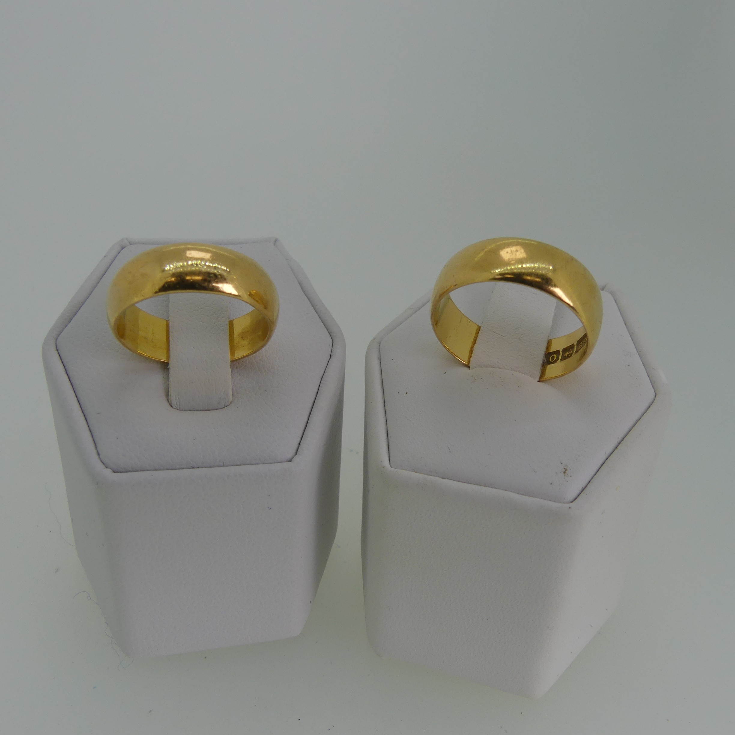Two 22ct yellow gold Bands, one 6.15mm wide, Size L½, the other 6.75mm wide, Size O, approx. total