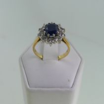 A sapphire and diamond cluster Ring, the oval facetted sapphire approx. 7.8x6mm, claw set with a