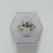 An three stone diamond Ring, illusion set on the cross and mounted in 18ct yellow and white gold,