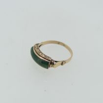 A Chinese jade Ring, the domed rectangular jade plaque mounted in 14ct rose gold with scrolled