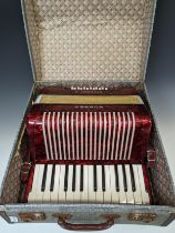 A vintage Hohner Student II Accordion, with red marbled-effect body, in carry case.