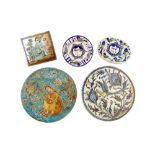 FOUR QAJAR-REVIVAL POLYCHROME-PAINTED POTTERY TILES AND A LATE QAJAR POTTERY DISH Iran, first half 2