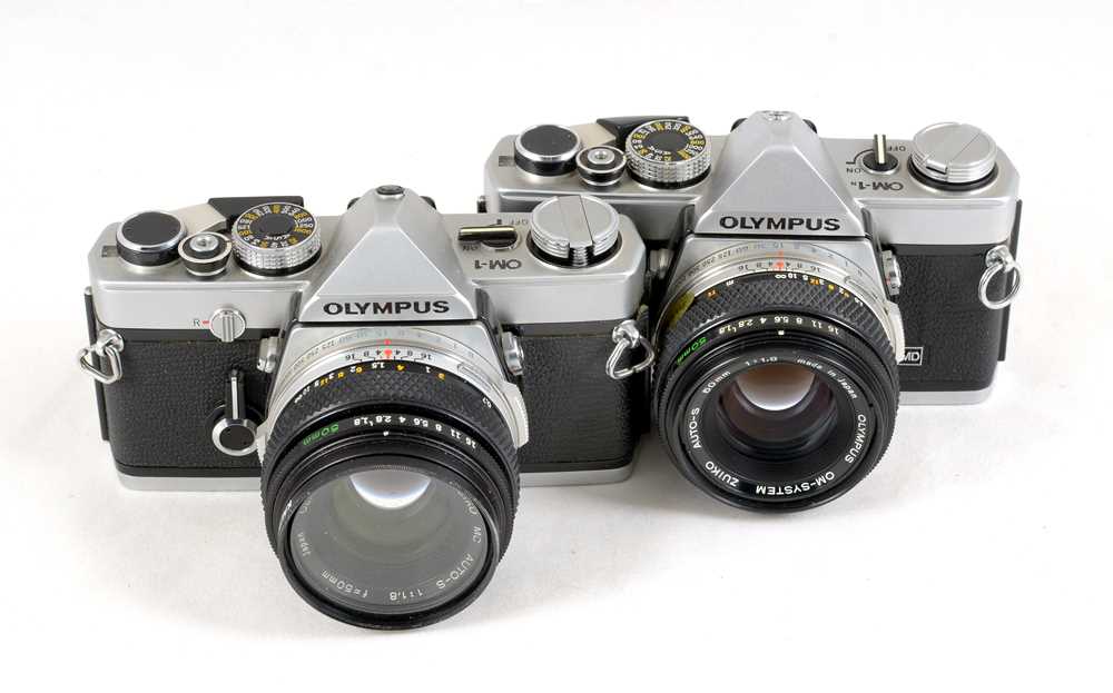 A Pair of Chrome Olympus OM-1 Cameras.