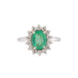 An emerald and diamond cluster ring