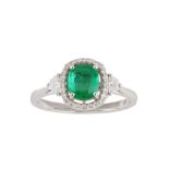 An emerald and diamond cluster ring