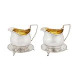 A highly unusual and rare pair of George III provincial sterling silver milk jugs or sauce boats on