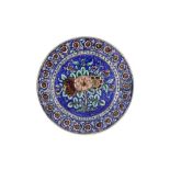 A POLYCHROME-PAINTED POTTERY PLATE WITH FLORAL DESIGN Possibly Tehran, Qajar Iran, mid to late 19th