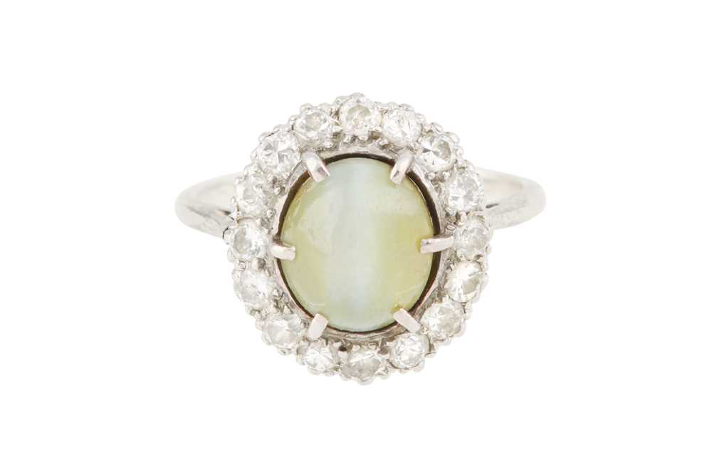 A CAT'S EYE CHRYSOBERYL AND DIAMOND CLUSTER RING