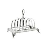 A Victorian sterling silver seven bar toast rack, London 1874 by Henry Holland