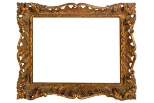 AN ENGLISH CARVED AND GILDED ROCOCO STYLE SWEPT AND PIERCED FRAME
