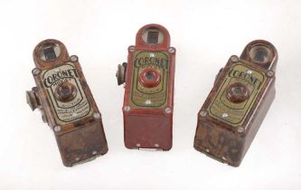 A Red & Two Mottled Brown Coronet Midget Cameras.