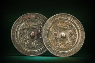 A NEAR PAIR OF CHINESE SILVERED BRONZE 'HORSE AND RIDER' MIRRORS 漢 騎馬狩獵紋鍍銀銅鏡兩面