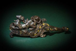 A CHINESE GOLD AND SILVER-INLAID BRONZE 'MYTHICAL BEAST' GARMENT HOOK, DAIGOU 戰國 銅錯金銀瑞獸紋帶鉤
