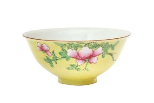 A CHINESE FAMILLE-ROSE YELLOW-GROUND SGRAFFITO BOWL 清十九世紀 黃地粉彩花卉紋盌