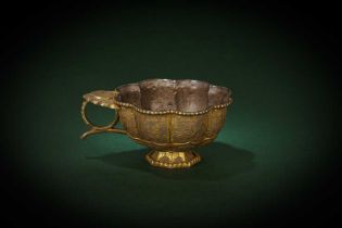 A CHINESE PARCEL-GILT SILVER CUP 唐 銀局部鎏金仕女狩獵紋八蓮瓣盃