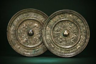 A NEAR PAIR OF CHINESE SILVERED BRONZE 'POEM' MIRRORS 唐 銘紋神獸紋鍍銀銅鏡兩面