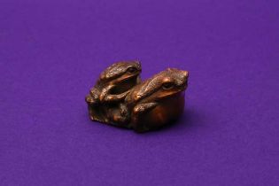 A JAPANESE BOXWOOD NETSUKE OF TWO TOADS