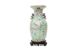 A CHINESE CELADON-GROUND FAMILLE-ROSE 'BUTTERFLIES AND BLOSSOMS' VASE 青釉粉彩繪瓶連木座