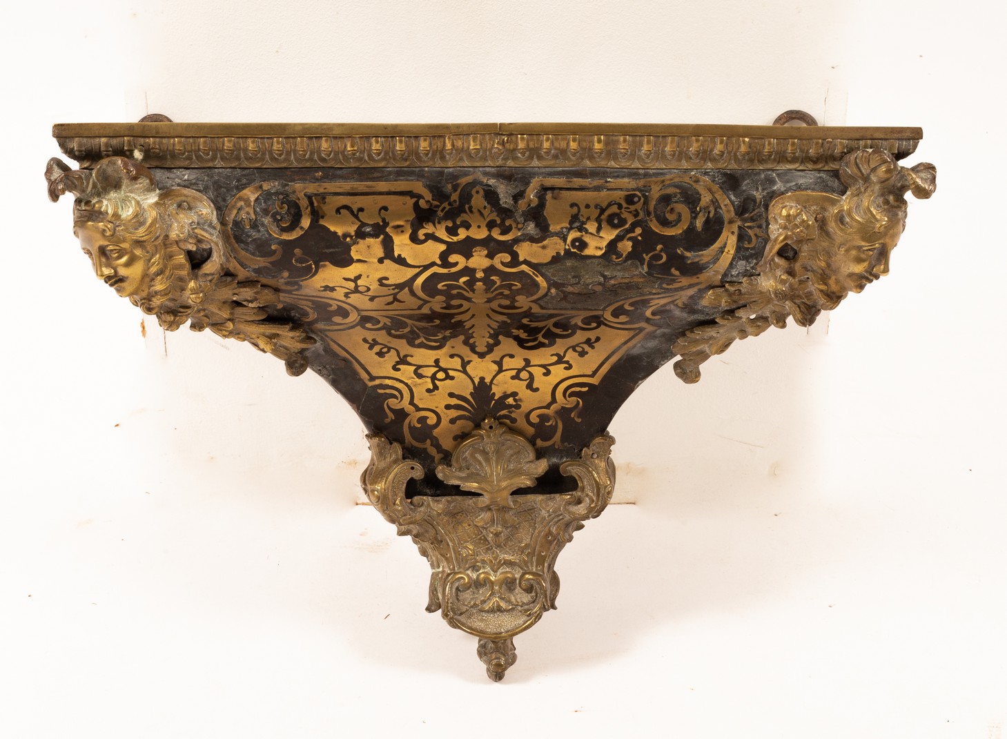 A Boulle work wall bracket with gilt metal mask head mounts to the front corners,