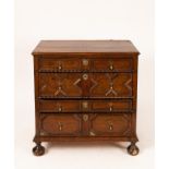 A Jacobean oak chest of three drawers on bun feet,