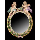 A 19th Century Meissen porcelain small circular dressing table mirror with two cupids atop,