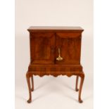A walnut cabinet on stand fitted interior with doors on cabriole legs,