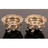 A pair of 19th Century circular silver salts, marks rubbed, each on four scrolled acanthus feet,
